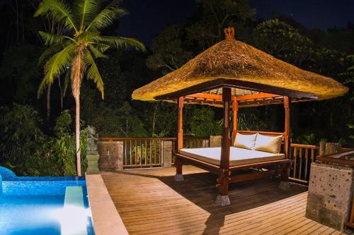 a gazebo on a deck next to a pool at Ubud Hills Villas & Resort in Ubud