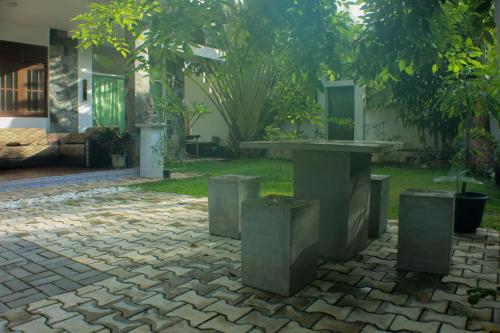 a stone courtyard with a table and trash cans at The Mango Leaf in Matara