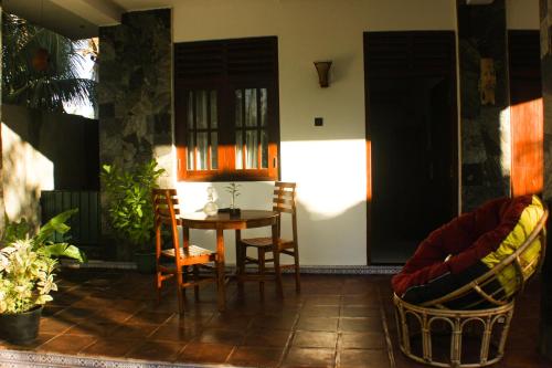 a room with a table and chairs on a patio at The Mango Leaf in Matara
