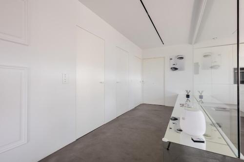 Cette chambre blanche dispose de murs blancs et d'une table. dans l'établissement Sea Lovers Apartment, à Alcúdia