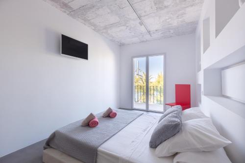 a white bedroom with a bed and a window at Sea Lovers Apartment in Alcudia