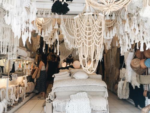 a store with white curtains and chandeliers at Lloyd's Inn Bali in Seminyak