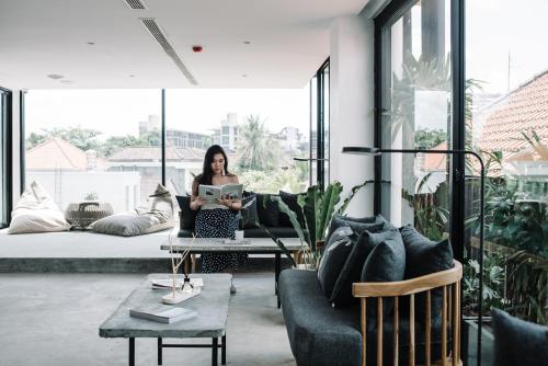 a woman standing in a living room with a laptop at Lloyd's Inn Bali in Seminyak