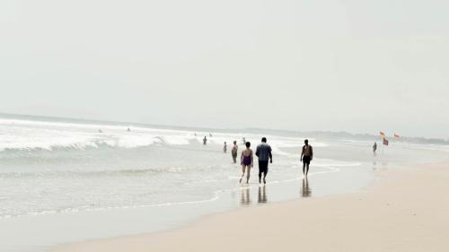 a group of people walking on the beach at Lloyd's Inn Bali in Seminyak