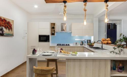 a kitchen with white cabinets and a table with chairs at Villa Mer Vue in Ambalangoda
