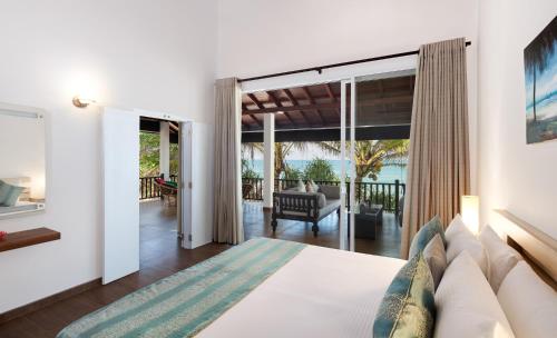 a bedroom with a bed and a living room at Villa Mer Vue in Ambalangoda