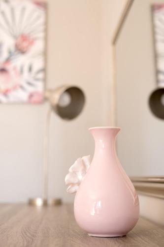 a white vase sitting on top of a wooden table at Gemstone Guest House in Klerksdorp