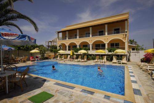 un hôtel avec une piscine et un bâtiment dans l'établissement Hotel Coral Beach, à Roda