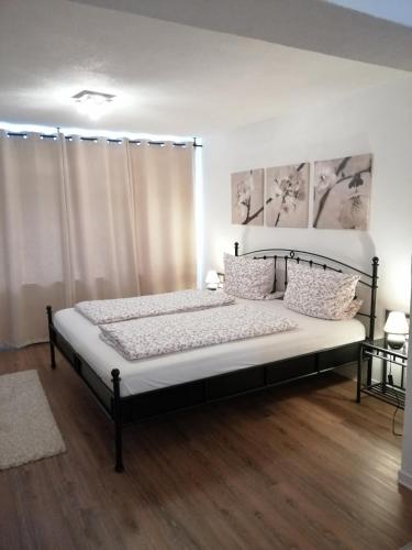 ルストにあるFerienwohnung Tislenkoのベッドルーム(白いカーテン付きの大型ベッド1台付)