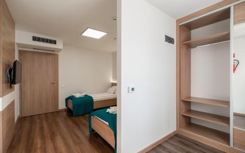 a small room with a bed and a sliding glass door at Hotel Szeghalom in Szeghalom