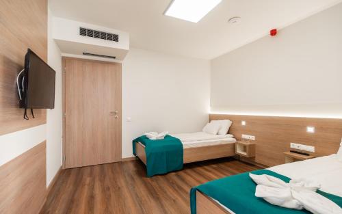 a small room with a bed and a television at Hotel Szeghalom in Szeghalom