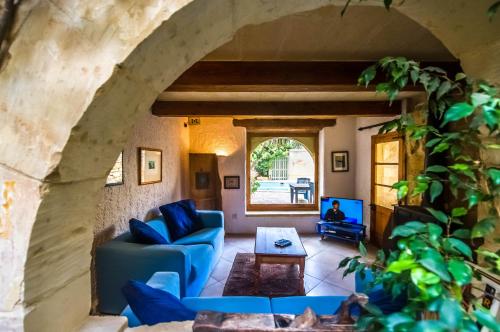 a living room with blue couches and a tv at Villa Ta Marija in Xagħra