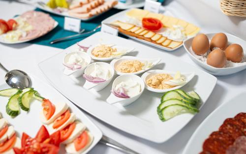 a buffet of food on a white table at Hotel Szeghalom in Szeghalom