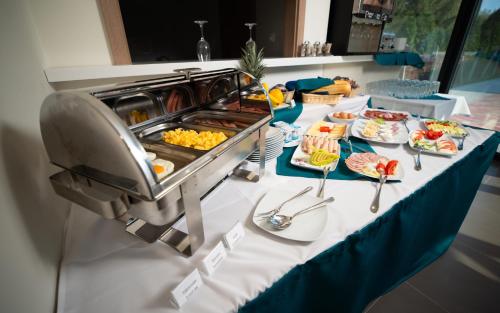 a buffet table with plates of food on it at Hotel Szeghalom in Szeghalom