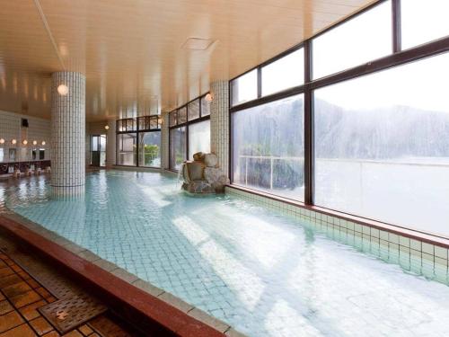 una grande piscina in un edificio con finestre di Kumano-bettei Nakanoshima a Katsuura