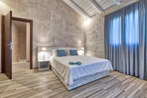 une chambre avec un lit et un mur en pierre dans l'établissement Villa Stagio, à Alykes