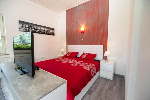 um quarto com uma cama vermelha e um cobertor vermelho em Apartment Lucija-Terme Šmarješke Toplice em Smarjeske Toplice