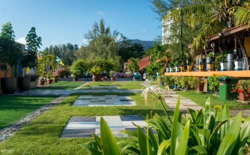 a view of a garden with plants and buildings at Lost Paradise Resort in Batu Ferringhi