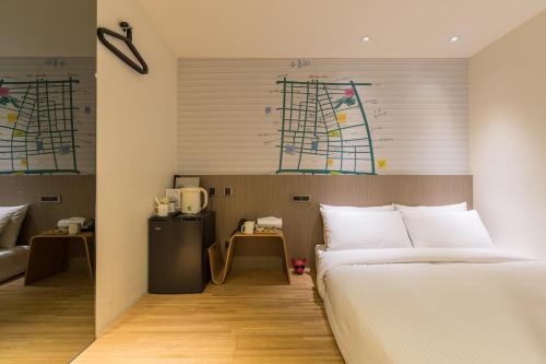 a hotel room with a bed and a desk at Chaiin Hotel - Dongmen in Taipei