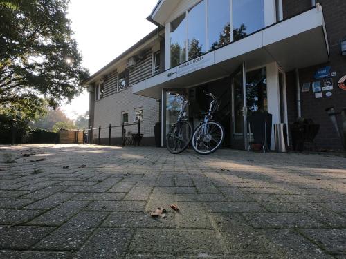 a bike parked in front of a building at Human & Horse Hotel in Kootwijkerbroek