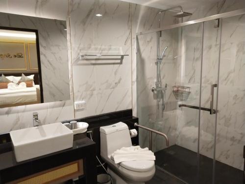 a bathroom with a shower and a toilet and a sink at Hotel De Sripoom in Chiang Mai