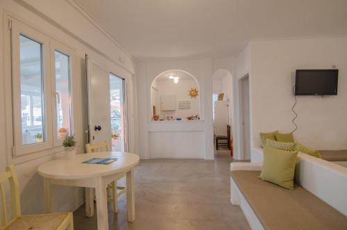 a white living room with a table and a couch at George & Irene Hotel in Ios Chora