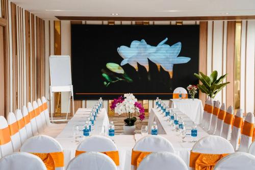 a conference room with white tables and chairs at Navada Beach Hotel in Nha Trang