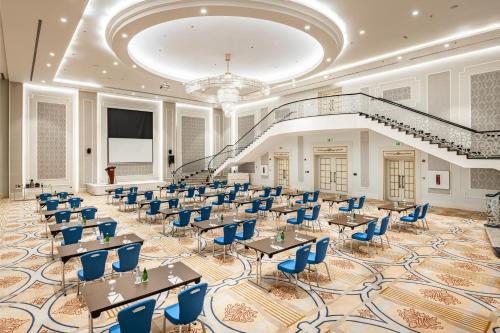 a banquet hall with tables and chairs and a staircase at Radisson Blu Plaza Jeddah in Jeddah