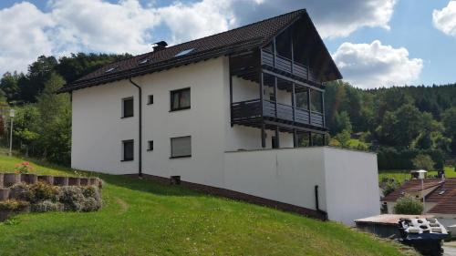 una casa blanca con techo negro en una colina en Ferienhaus KorsikaBlick en Unter Schönmattenwag