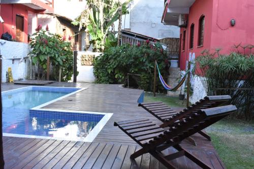 una terrazza in legno con panchina accanto alla piscina di Pico das Praias Suites a Itacaré