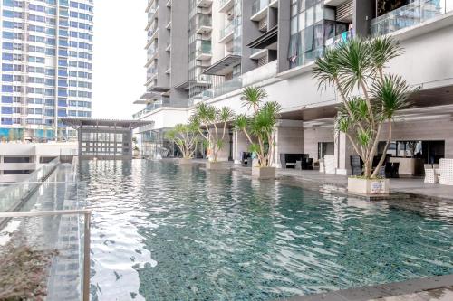 a swimming pool in the middle of a building with palm trees at Rex Ollie @ The Elements Ampang in Kuala Lumpur