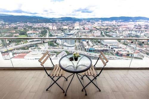 a table and chairs on a balcony with a view of a city at Rex Ollie @ The Elements Ampang in Kuala Lumpur