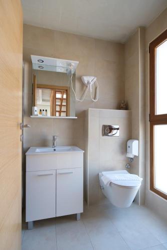 a bathroom with a white sink and a toilet at Grad Sunca Resort in Trebinje