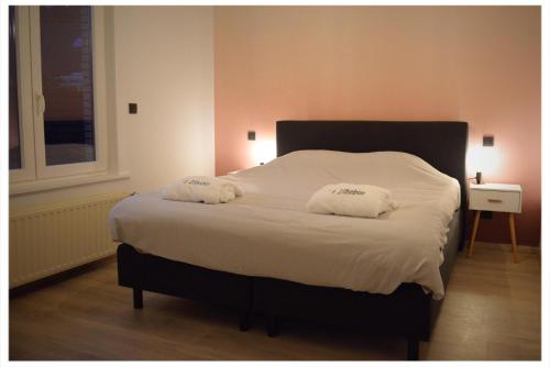 - un lit avec 2 oreillers blancs au-dessus dans l'établissement ‘t Ziltebos, à Wenduine