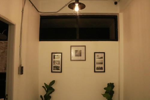 a room with three pictures on a wall with a window at Backpack Hostel in Chiang Rai
