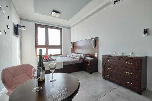 弗次瓦夫的住宿－Lux Apartment Center，一间卧室配有一张床和一张带酒杯的桌子