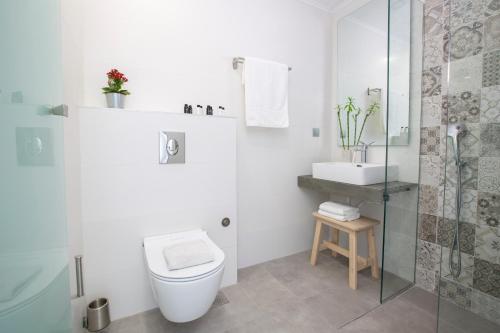 a white bathroom with a toilet and a sink at Rachi Sea View White Villa in Episkopos