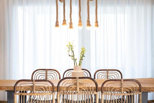 a dining room table with four chairs and a vase at Rachi Sea View White Villa in Episkopos