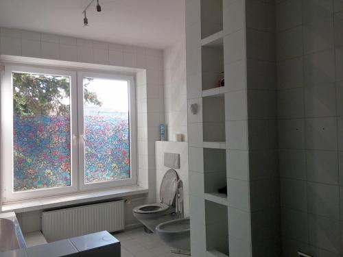 a bathroom with a toilet and a window at Mira Rent House in Warsaw