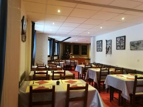a dining room with white tables and chairs at Les Carlines in Vars