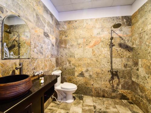 a bathroom with a shower and a toilet and a sink at OYO 473 Suburban Villa in Hoi An