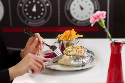 a person sitting at a table with a plate of food at Ibis Praha Mala Strana in Prague