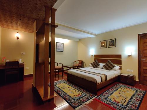a bedroom with a bed and a room with a table at Hotel Tarayana in Gangtok