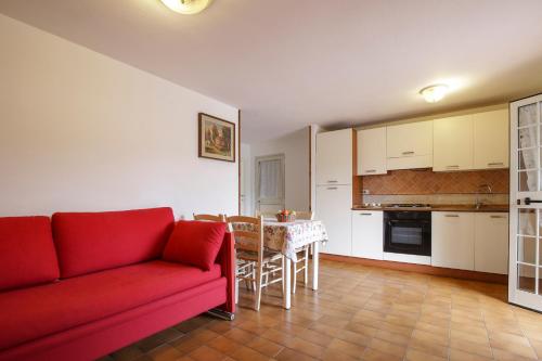 a living room with a red couch and a table at Casa Giulia - HelloElba in Marina di Campo