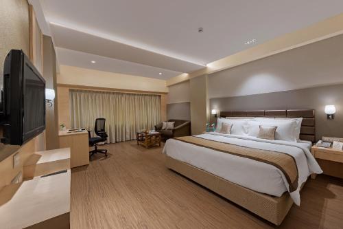 a hotel room with a large bed and a television at The Fern Residency Aurangabad - Chhatrapati Sambhaji Nagar in Aurangabad