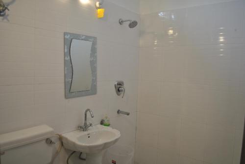 a bathroom with a sink and a toilet and a mirror at Hotel Maha Luxmi Palace in Katra