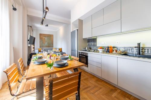 雅典的住宿－Hidesign Athens Luxury Apartments in Kolonaki，厨房以及带桌椅的用餐室。