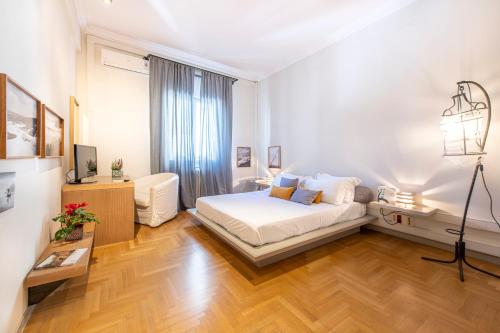 アテネにあるHidesign Athens Luxury Apartments in Kolonakiの白いベッドルーム(ベッド1台、デスク付)