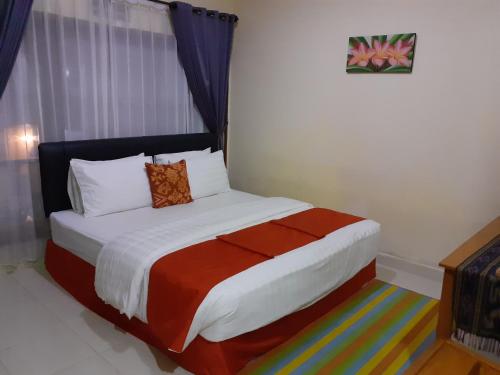 a bedroom with a large bed with a colorful blanket at Griya Bun Sari in Sukawati
