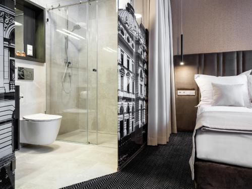 a hotel room with a shower and a bed at Hotel Logos Kraków in Krakow